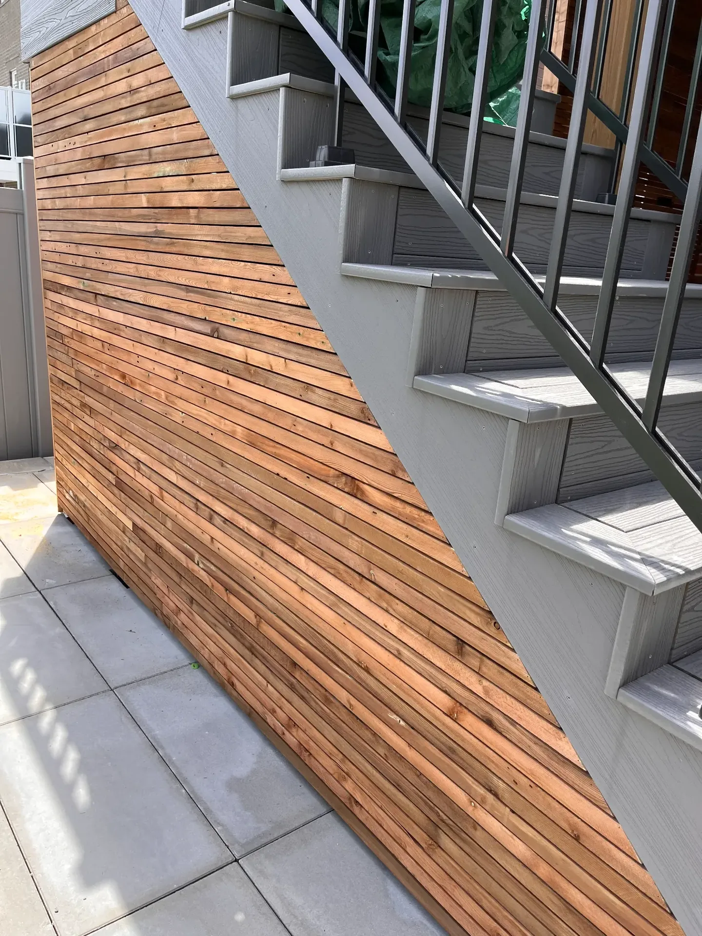 Exterior steps with horizontal wood privacy screen and black railing