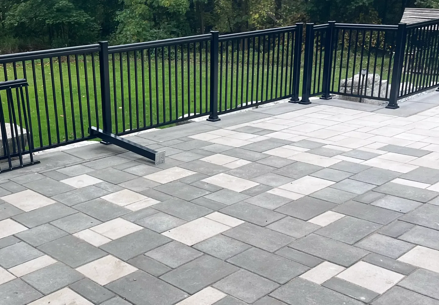 Black metal railing around a paved outdoor area