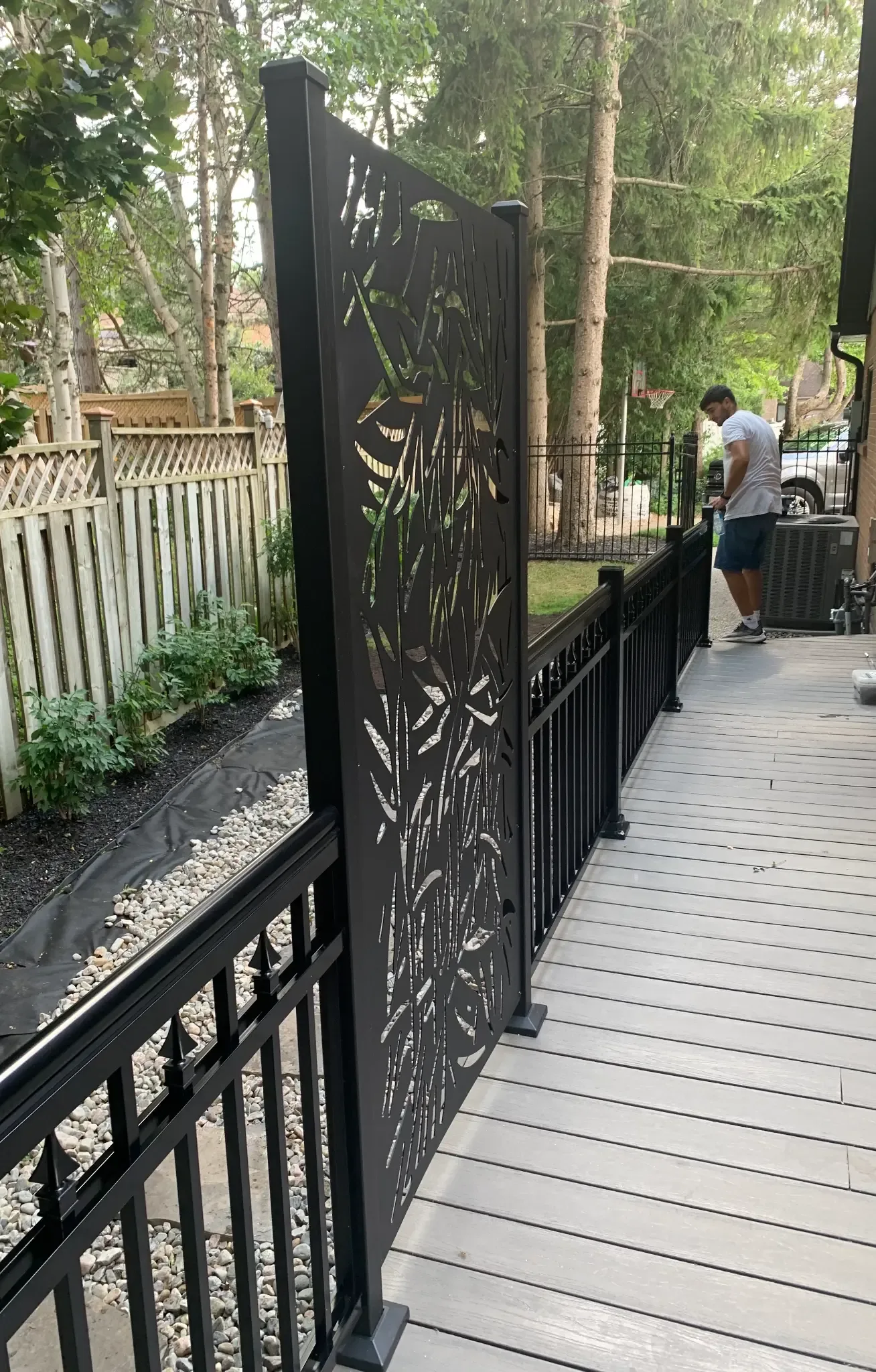Decorative black metal railing and privacy panel beside a deck